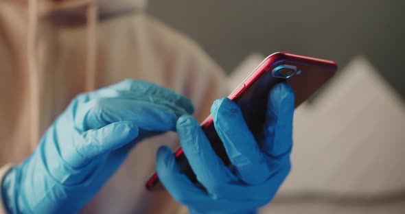 Man in Latex Blue Gloves Scrolling a Smart Phone in a Supermarket