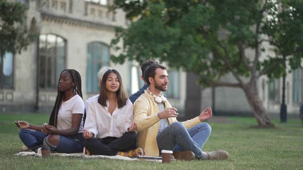 Young Diverse Students Maditating on Campus Lawn