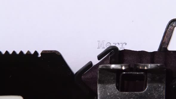 Man Is Typing a Letter on the Typewriter of a Merry Christmas