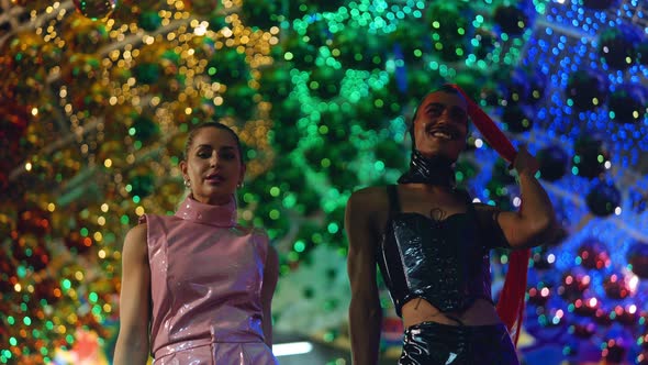 Clubbers In Pvc Fashion Walking To Camera Amongst Neon Lights