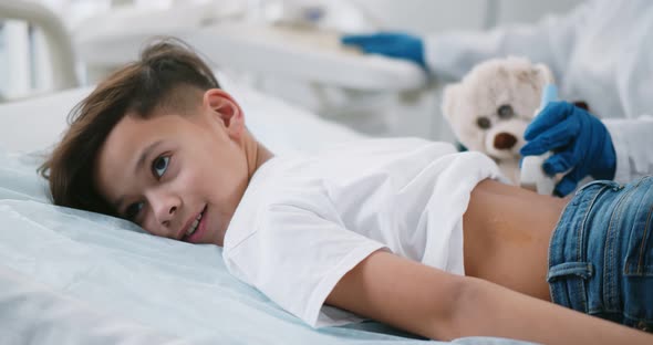 Close Up of Doctor Performing Kidney Ultrasound Scan on Preteen African Boy