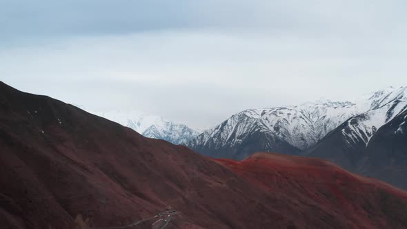 Bird'seye View of a Mountain Landscape with Huge Rocky Mountains and Winding Roads Along Which