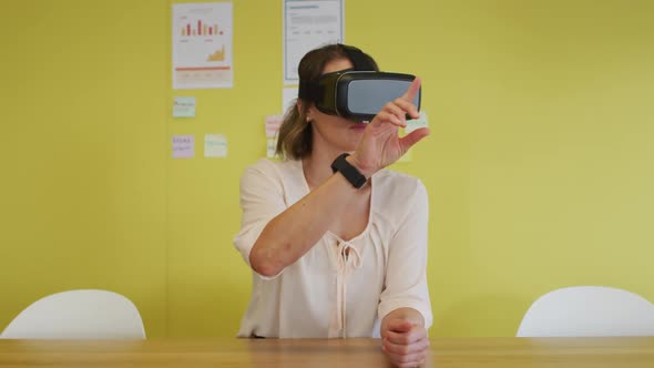 Caucasian businesswoman sitting at desk, testing vr googles