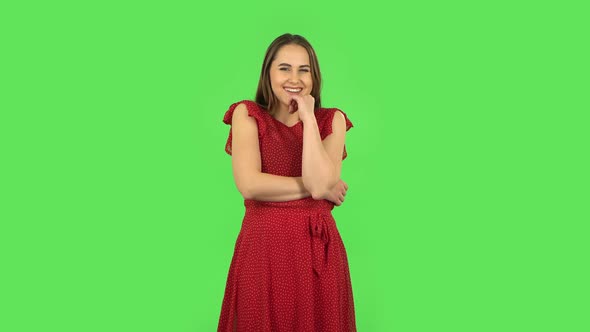 Tender Girl in Red Dress Communicates with Someone in a Friendly Manner. Green Screen