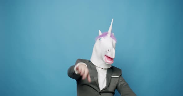 Happy Guy in Gray Suits He is Having Fun with Unicorn Mask