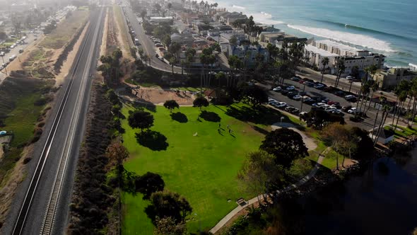 Aerial approach of a park with people playing and sun bathing