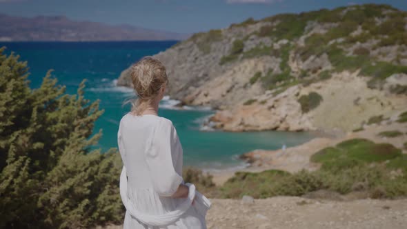 A Beautiful Young Woman in a White Dress Against the Backdrop of a Delightful Seascape