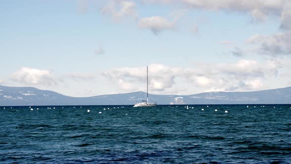 Sailboat and buoys in Lake Tahoe California on cloudy day, Handheld stable shot