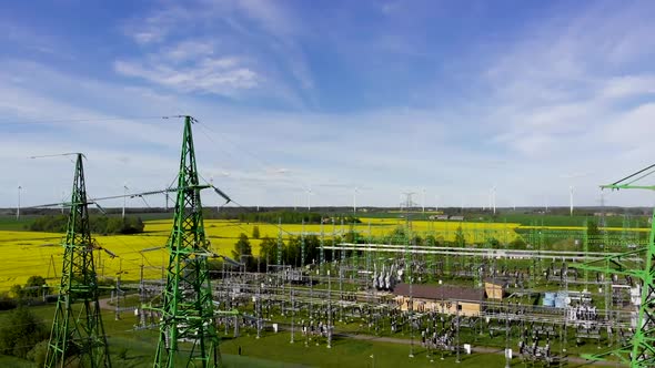 Aerial Fly Back: Green Power Plant with Windmills in Background