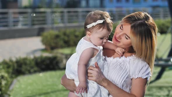 Happy Mom Expressing Love for Baby Girl on Walk