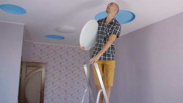 A Man Is Going To Install an Led Ceiling Light