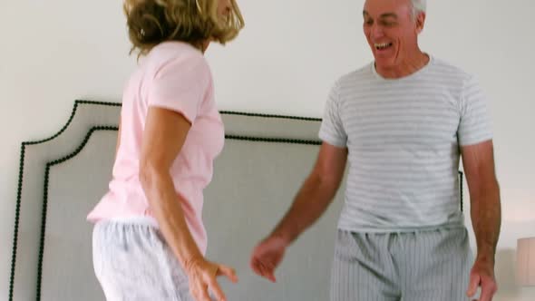 Happy senior couple dancing on bed