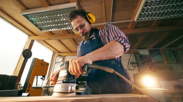 Slow Motion of a Male Carpenter Polishing a Wooden Block