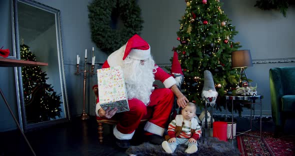 Cute Little Boy Santa Claus Holding Giftbox Looking It