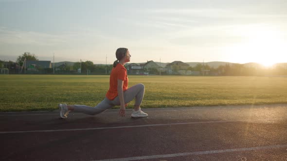 Young Beautiful Girl in Sweatpants and an Orange Tshirt Goes in for Sports