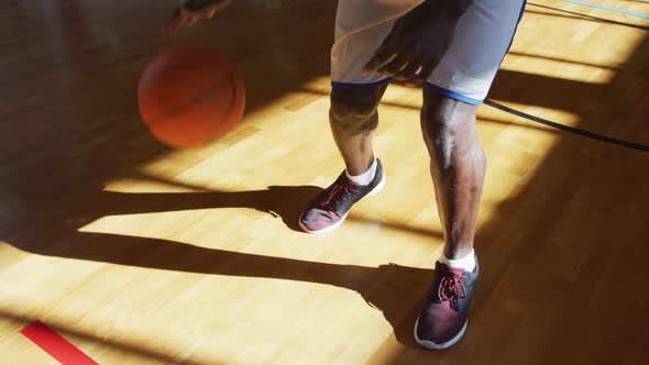African american male basketball player practicing dribbling ball