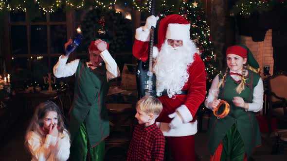 Santa Claus sings and dances with children and elves