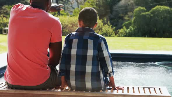 Father talking to son near pool side