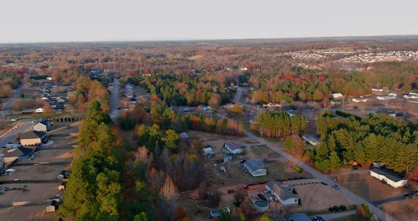 Aerial View of Colorful Autumn Fall Trees Foliage with Houses in Countryside Rural Road Small Town