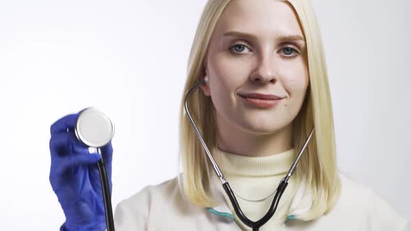 Happy Smiling Female Doctor in White Coat with Stethoscope Showing