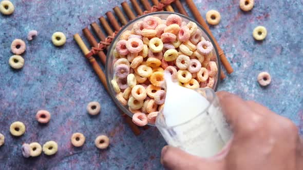 Slow Motion of Pouring Milk on Colorful Cereal Corn Flakes in a Bowl