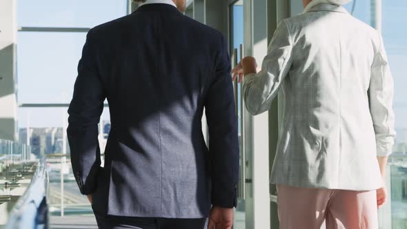 Two young business people walking in a modern office