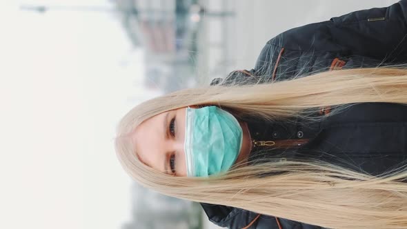 Coronavirus Pandemic Blonde Woman in a Medical Mask Walking Down the Street