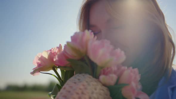 Portrait of Beautiful Woman Smelling Gentle Flower Bouquet in Sun Reflection