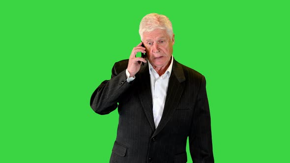 Senior Businessman Walking and Making a Call on a Green Screen Chroma Key
