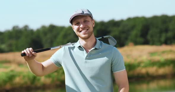 Outdoor Portrait of Young Bearded Man Posing with Golf Stick, Smiling To Camera, Tracking Shot