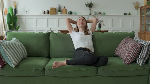 Female Enjoying Moments of Tranquility and Comfort Relaxing on Sofa at Home