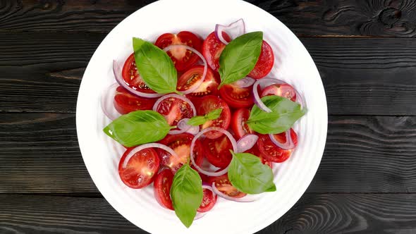 Tomato Salad with Basil and Chopped Onion in White Ceramic Dish Rotate Slowly