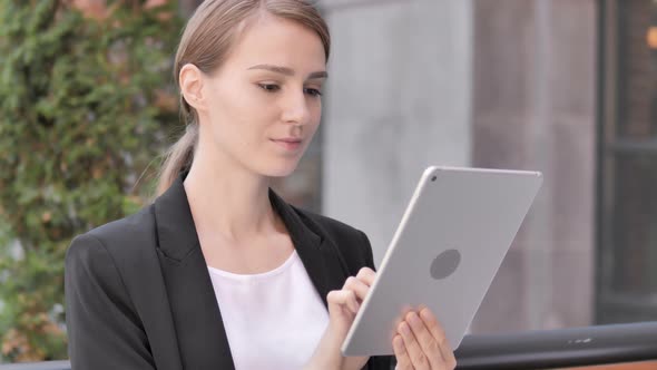 Young Businesswoman Sitting Outdoor and Using Tablet