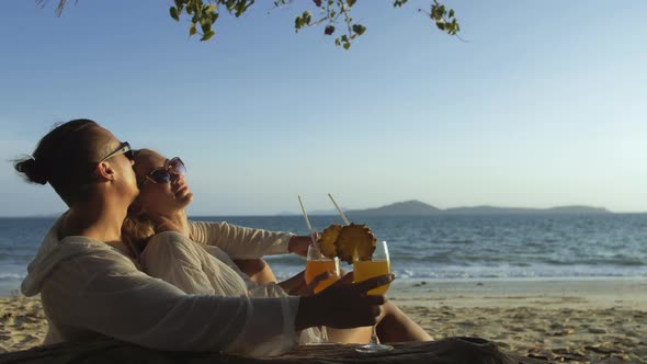 Loving Couple in White Dress Sunglasses in Hugging Relax and Drinking Cocktail