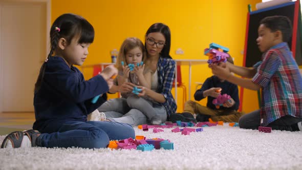 Asian Little Girl Playing with Constructing Blocks