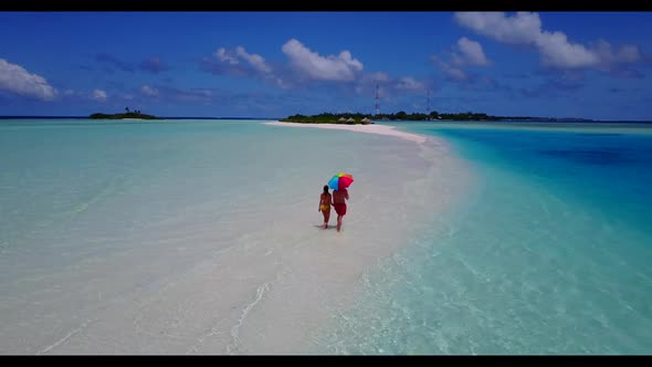 Boy and girl suntan on idyllic resort beach vacation by aqua blue sea and white sand background of t