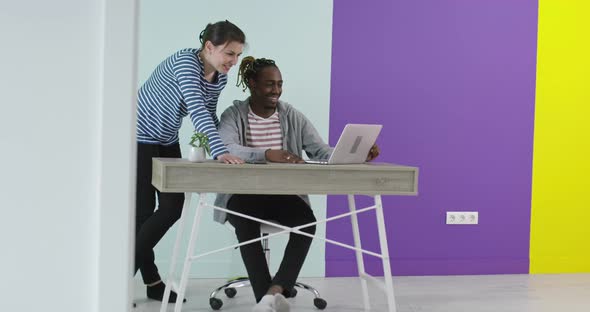 Positive Smiling Man and Woman Near Working Place with Laptop Cooperating in Office