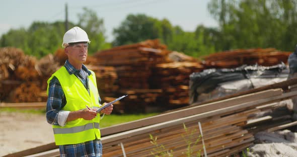 Male Worker Examining Plank's Stack