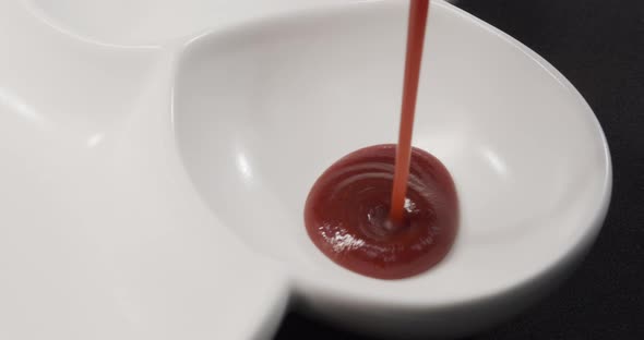 Pouring The Sauce Into A White Plate