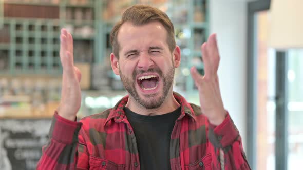 Portrait of Angry Young Man Shouting, Screaming