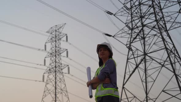 Female electrical engineer working near to High voltage tower