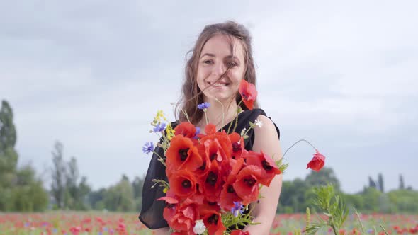 Portrait Cute Young Woman Holding Bouquet of Flowers in Hands Looking in the Camera Standing in a