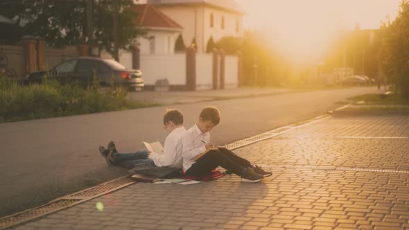 students sitting on road prepare for exam against sunlight