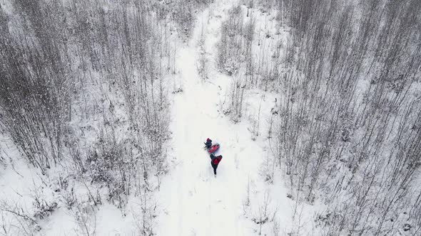 Mom and Child Ride a Tubing in Winter