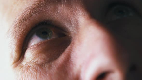 Man with Green Eyes Looks Up Under Bright Electric Light