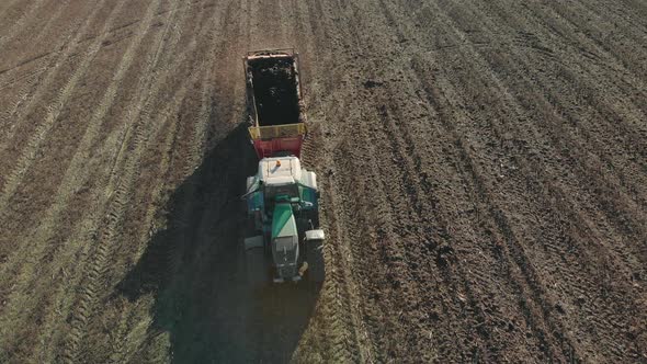 Aerial: Tractor Spreads Manure on the Sod-podzolic Soil of Farmland To Improve Yields