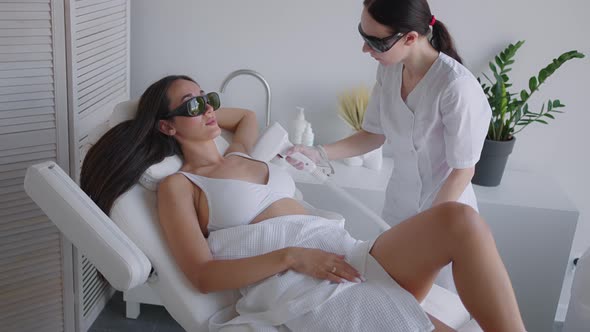 A Female Cosmetologist Does Laser Hair Removal of the Armpits in a Beauty Salon