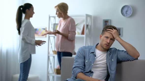 Exhausted Male Listening Wife and Mother-In-Law Arguing at Home, Rivalry