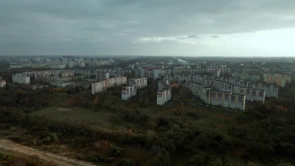 Construction of a city block next to a forested area. Photographed in cloudy weather.