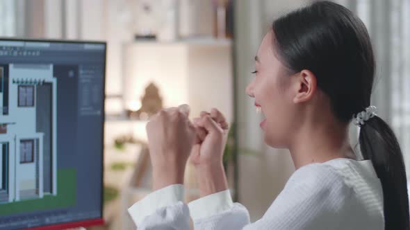 Close Up Of Asian Woman Engineer Celebrating While Designing House On A Desktop At Home